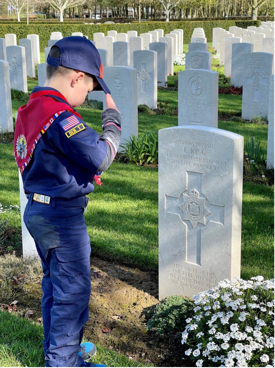 ub scout saluting headstone at U.S. Memorial